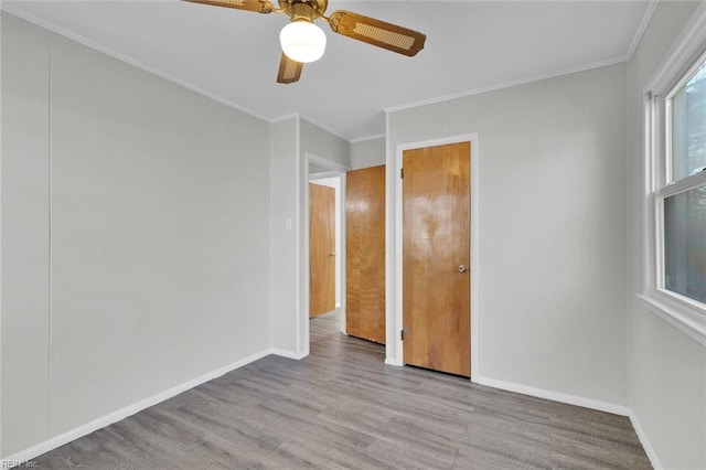 unfurnished bedroom with ceiling fan, ornamental molding, and light wood-type flooring