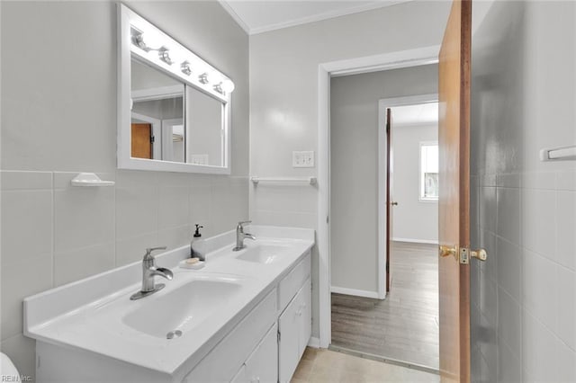 bathroom featuring tile walls, vanity, hardwood / wood-style flooring, and ornamental molding