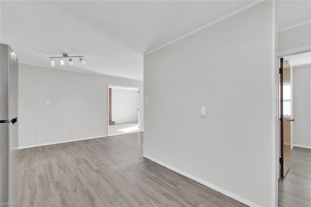 unfurnished room with ornamental molding and wood-type flooring