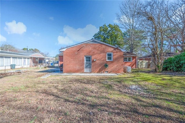 back of house with central AC unit, a lawn, and a patio area