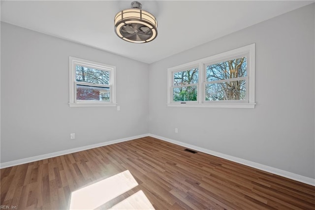 spare room featuring plenty of natural light and hardwood / wood-style floors