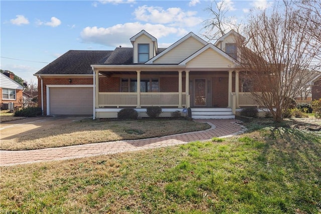 view of front of property featuring a garage, a front lawn, and a porch