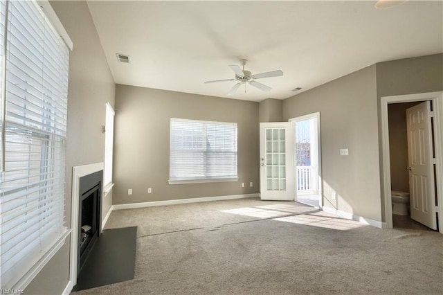 unfurnished living room with light colored carpet and ceiling fan