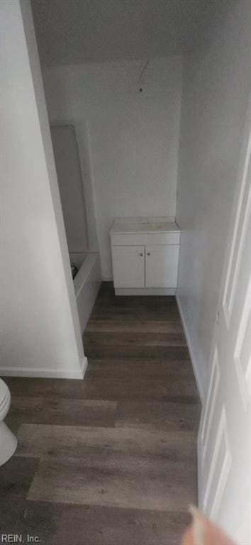 bathroom featuring hardwood / wood-style flooring, a tub, and toilet