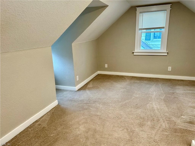 additional living space featuring lofted ceiling and carpet floors