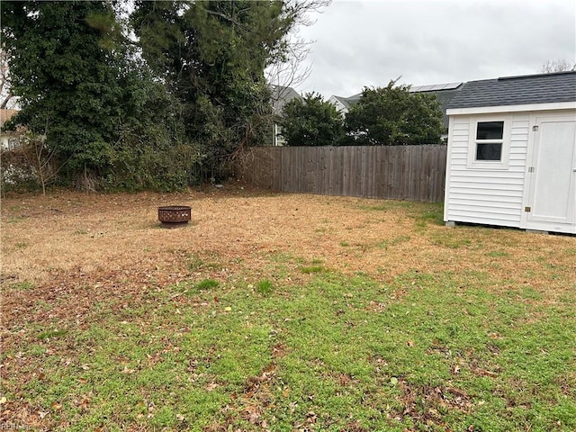 view of yard featuring a storage shed and a fire pit