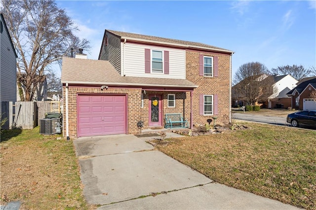 view of front of property with a garage, central AC, and a front yard