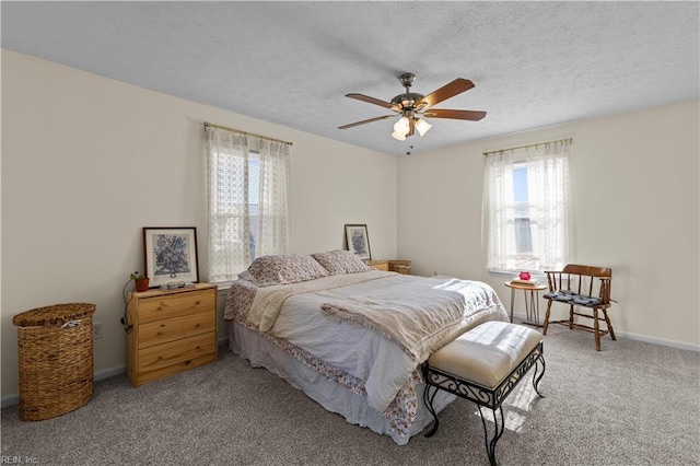 carpeted bedroom featuring ceiling fan and a textured ceiling