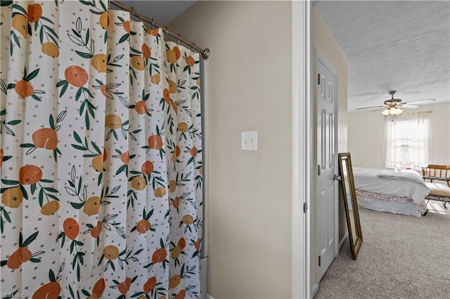 bathroom featuring ceiling fan, a shower with curtain, and a textured ceiling