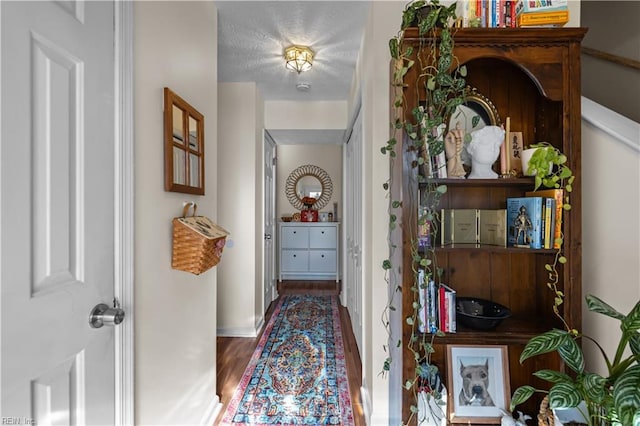 hallway featuring dark wood-type flooring and a textured ceiling