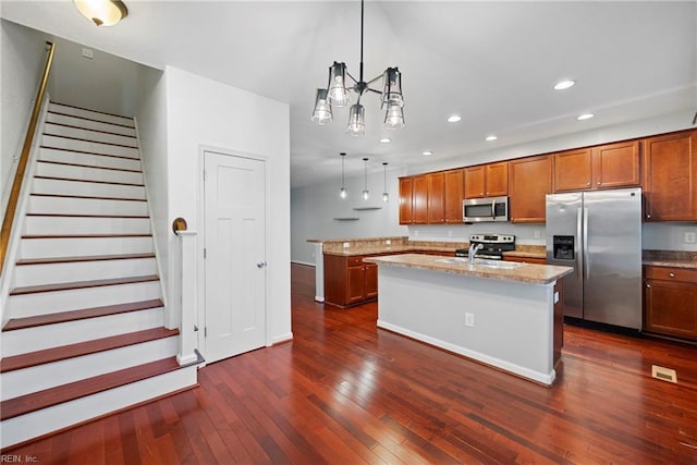 kitchen with a sink, brown cabinetry, stainless steel appliances, and dark wood-type flooring