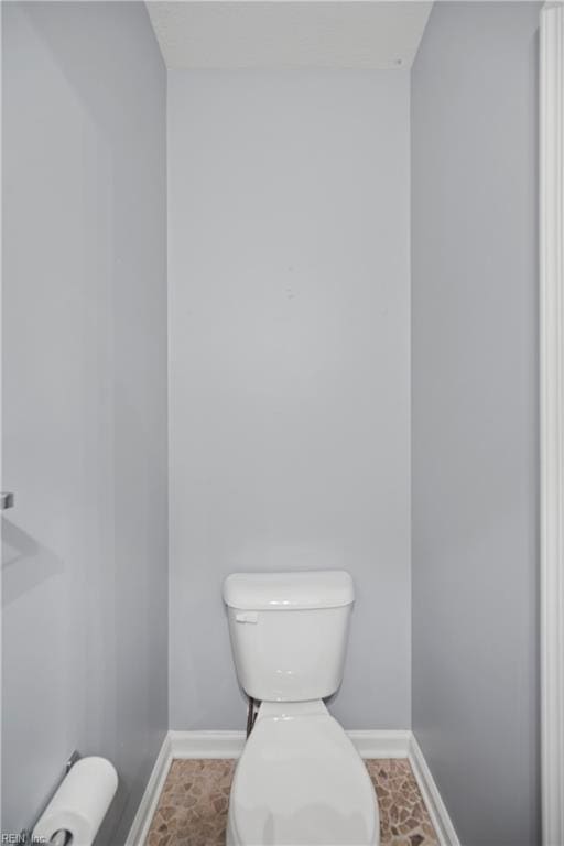 bathroom featuring toilet and baseboards