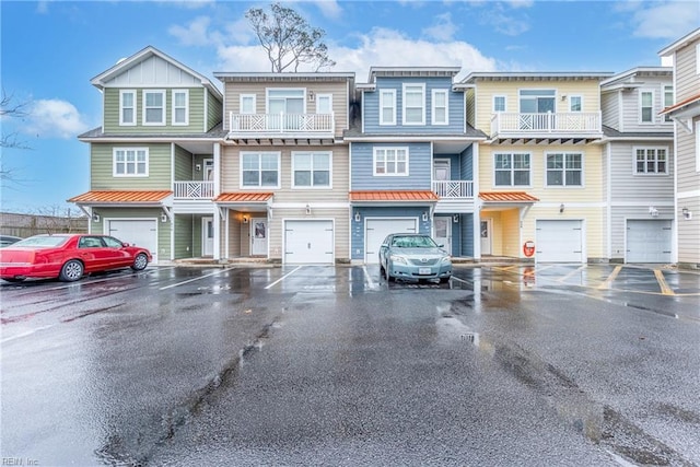 townhome / multi-family property with a garage, driveway, board and batten siding, and a standing seam roof