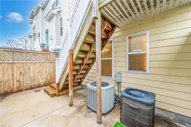 view of patio featuring central AC unit, stairway, and fence