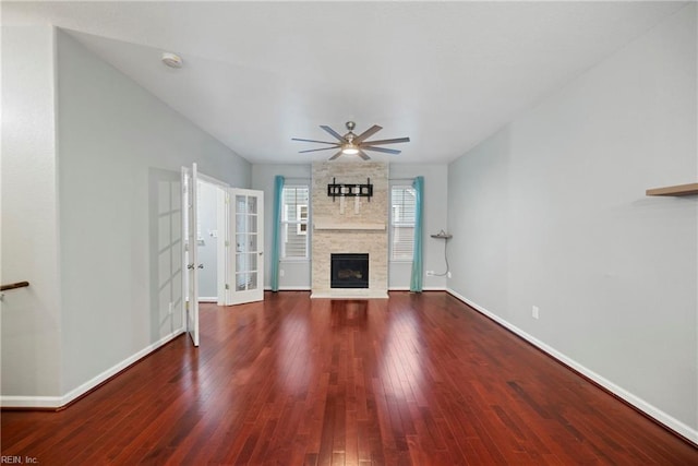 unfurnished living room featuring ceiling fan, a fireplace, baseboards, and hardwood / wood-style floors