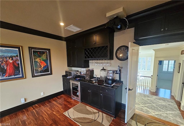 kitchen with crown molding, dark wood-type flooring, sink, and wine cooler