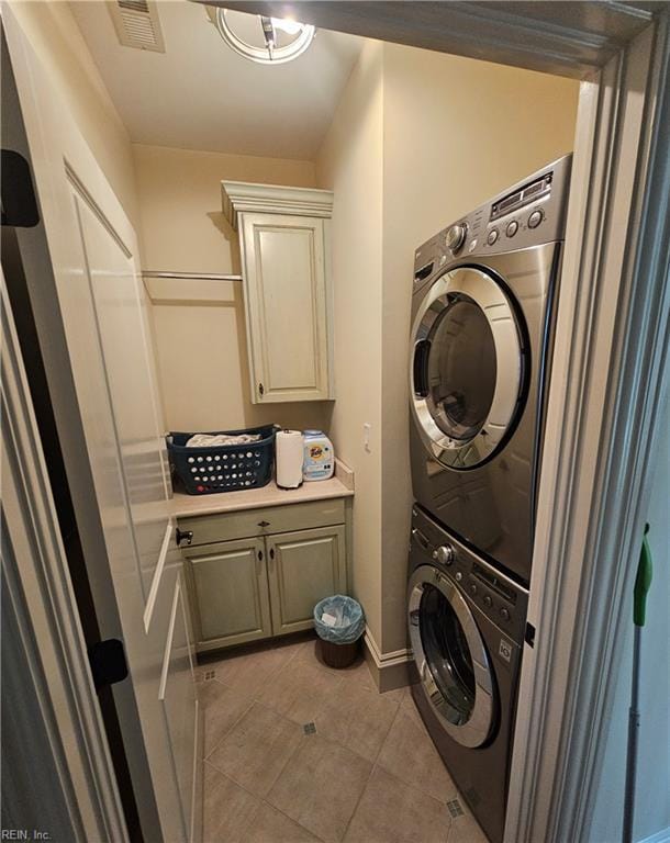 washroom featuring stacked washer / dryer and light tile patterned floors