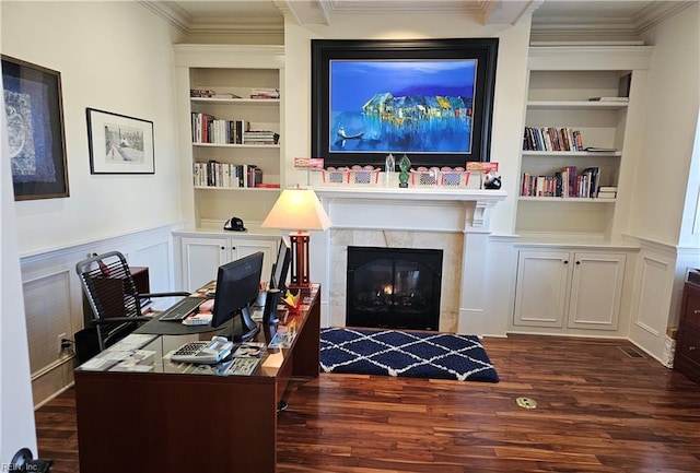 office featuring ornamental molding, dark hardwood / wood-style floors, a tile fireplace, and built in features