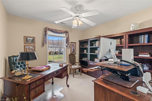 carpeted home office featuring ceiling fan