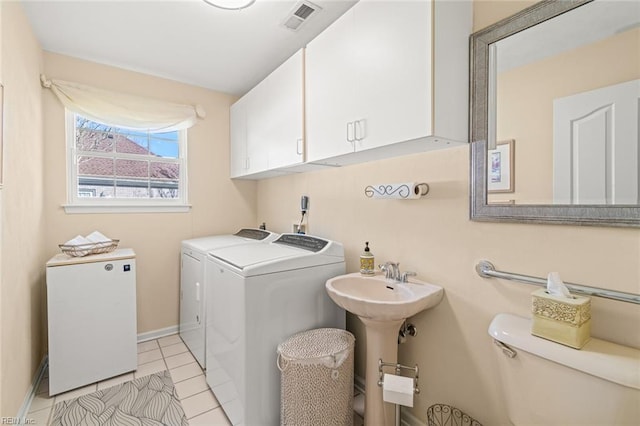 laundry area featuring sink, cabinets, light tile patterned floors, and independent washer and dryer