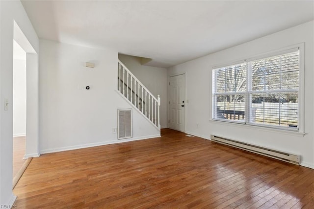 unfurnished living room featuring hardwood / wood-style floors and a baseboard radiator