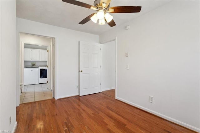 unfurnished bedroom featuring light hardwood / wood-style floors, independent washer and dryer, and ceiling fan