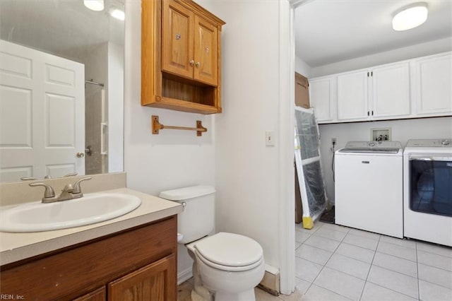 bathroom with tile patterned floors, toilet, washer and clothes dryer, and vanity