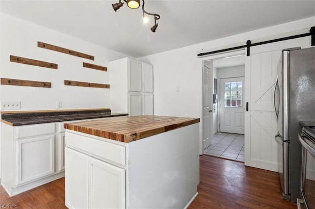 kitchen with white cabinetry, a center island, butcher block counters, and dark hardwood / wood-style flooring