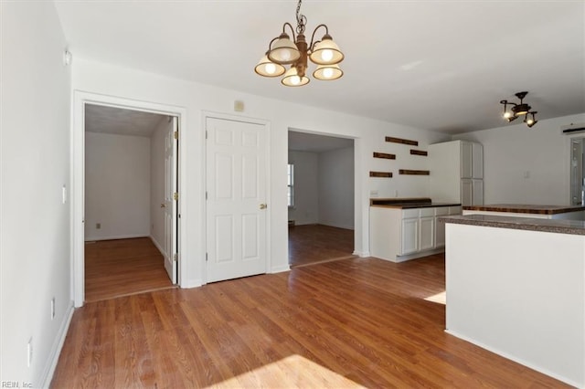 kitchen featuring an inviting chandelier, decorative light fixtures, light hardwood / wood-style flooring, and white cabinets