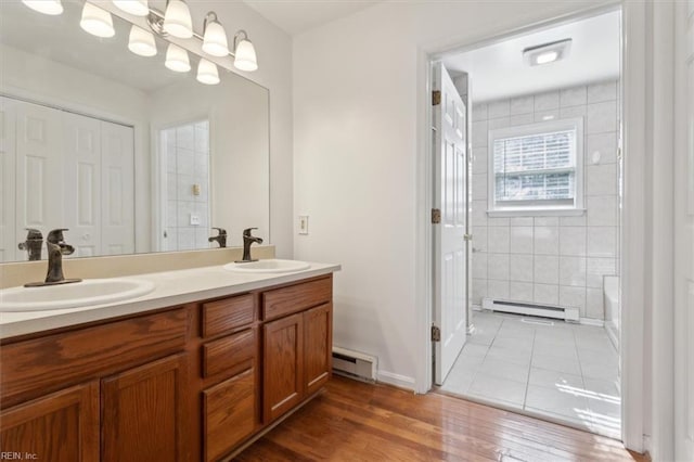 bathroom with a baseboard radiator, vanity, and hardwood / wood-style floors