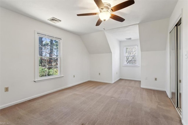 additional living space featuring vaulted ceiling, light colored carpet, and ceiling fan