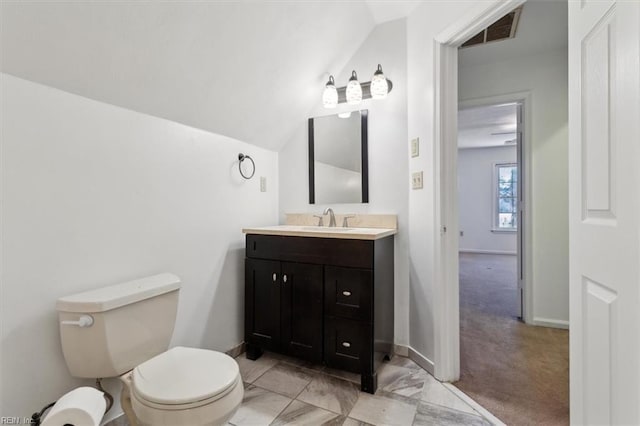 bathroom featuring vanity, lofted ceiling, and toilet