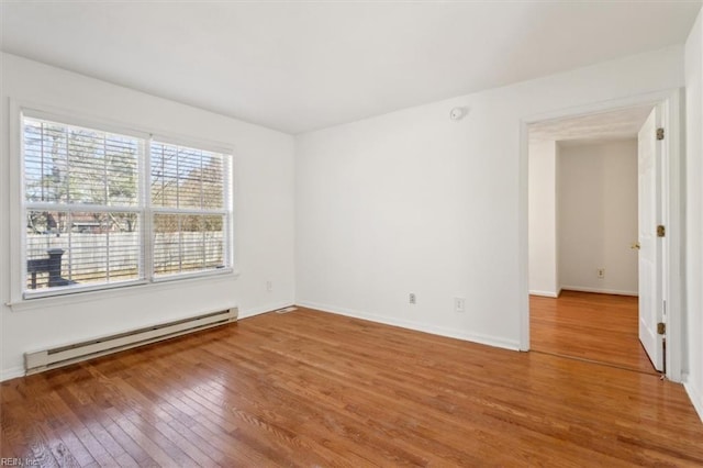 empty room featuring a baseboard radiator and wood-type flooring