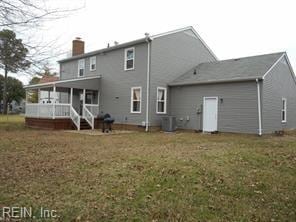 back of property featuring a lawn