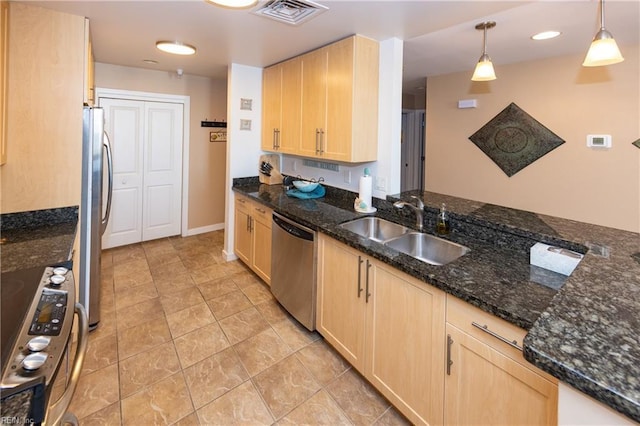 kitchen featuring sink, dark stone counters, decorative light fixtures, stainless steel appliances, and light brown cabinetry