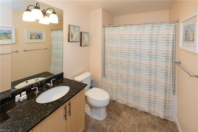 bathroom featuring curtained shower, vanity, and toilet