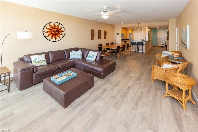 living room featuring light hardwood / wood-style flooring and ceiling fan