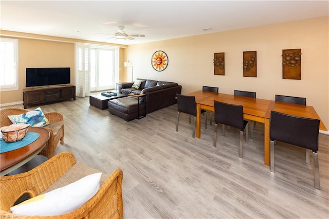 living room with light hardwood / wood-style flooring and ceiling fan