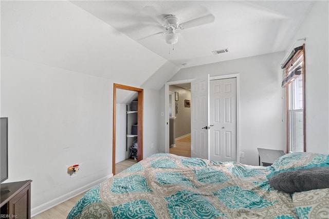 bedroom with vaulted ceiling, ceiling fan, light hardwood / wood-style floors, and a closet