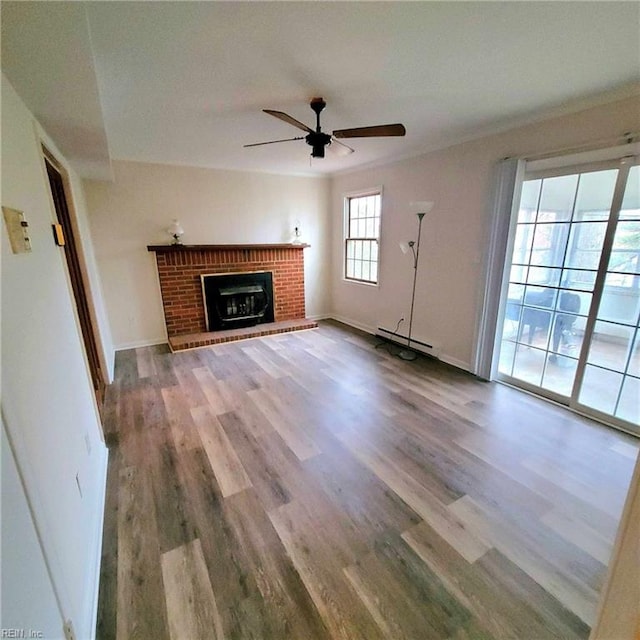 unfurnished living room featuring a fireplace, wood finished floors, a ceiling fan, and baseboards