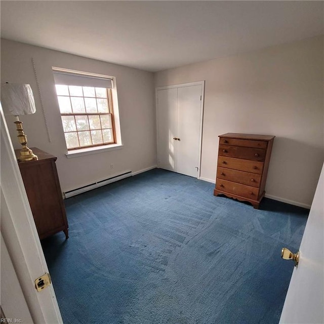 unfurnished bedroom featuring a closet, baseboard heating, carpet flooring, and baseboards