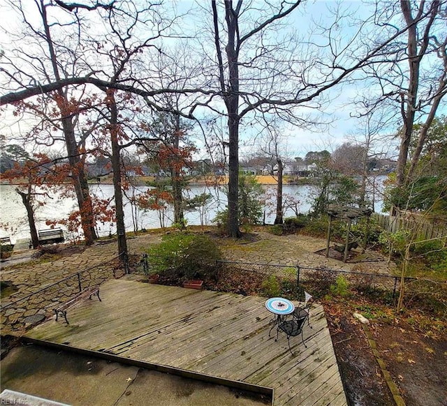 deck with a water view and fence