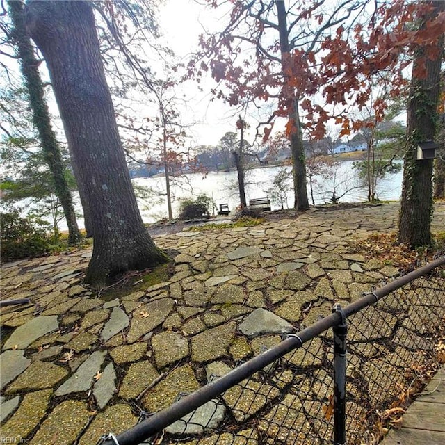 exterior space with a water view and fence