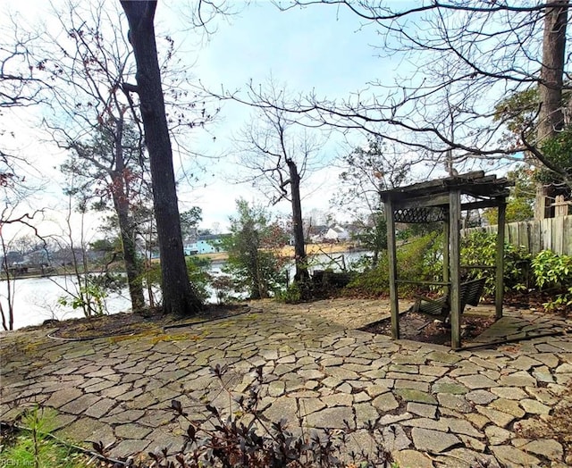 view of patio / terrace with a water view, fence, and a pergola