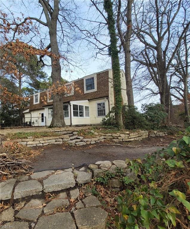 colonial inspired home with roof with shingles