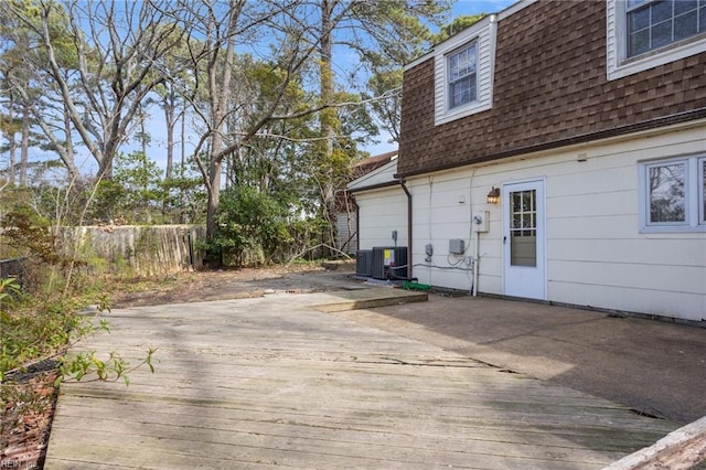 exterior space featuring roof with shingles, a wooden deck, and fence