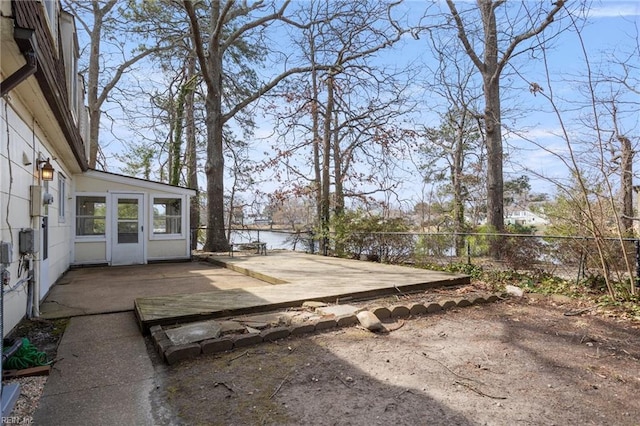 view of yard with a deck with water view and fence