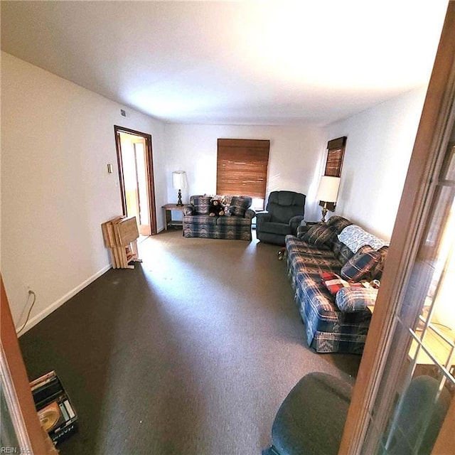 carpeted living area with baseboards and a healthy amount of sunlight