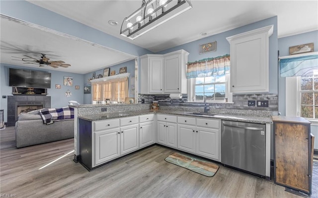 kitchen featuring white cabinets, sink, kitchen peninsula, and dishwasher