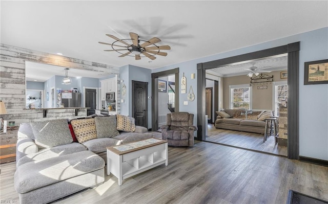 living room featuring ceiling fan and light wood-type flooring